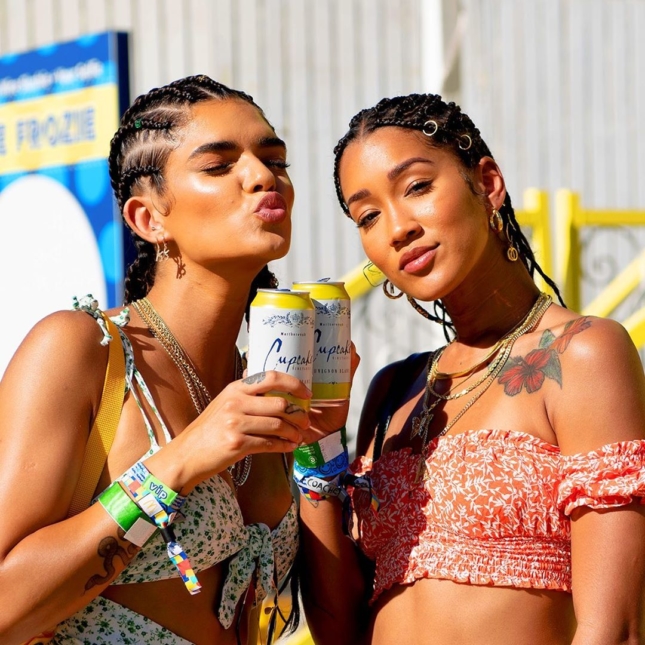 Two friends enjoying Cupcake wine cans at a music festival