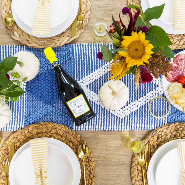 Cupcake on a bright and simple Thanksgiving tablescape with a bottle of Prosecco